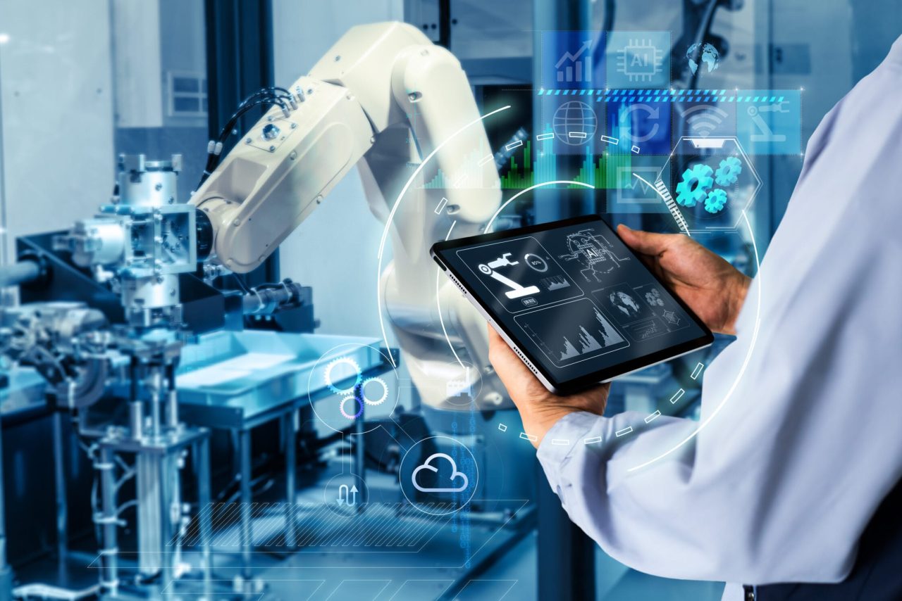 Smart industry control concept.Hands holding tablet on blurred automation machine as background